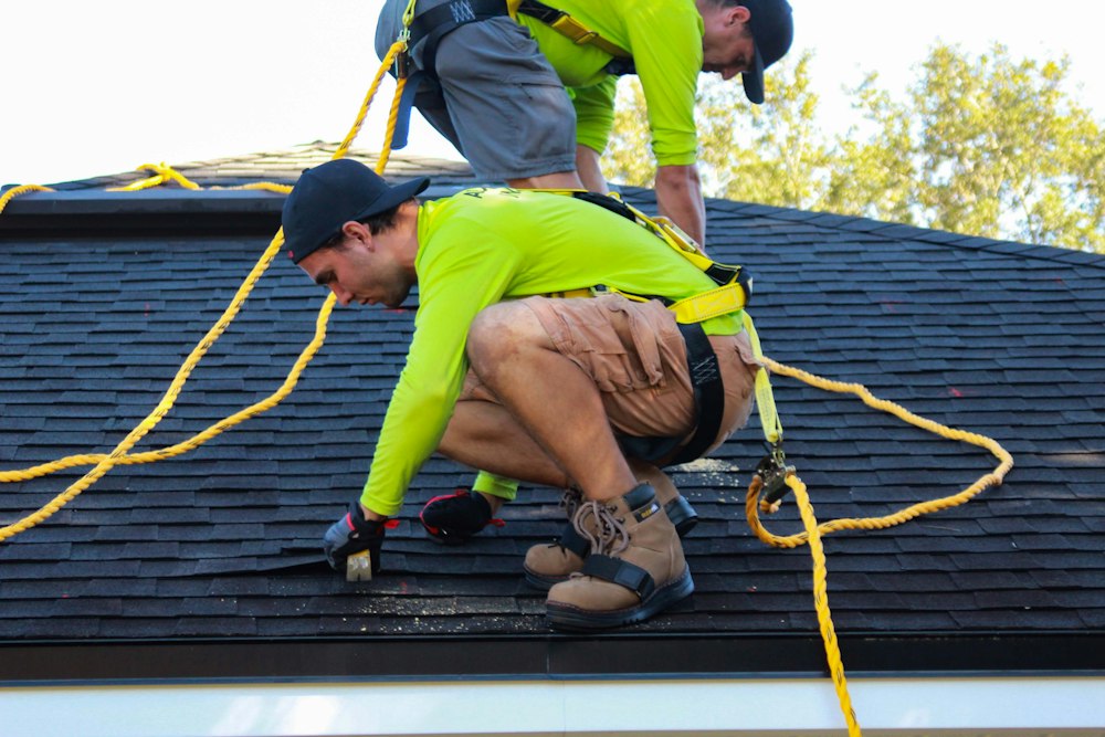 Roofing contractors repairing residential roof